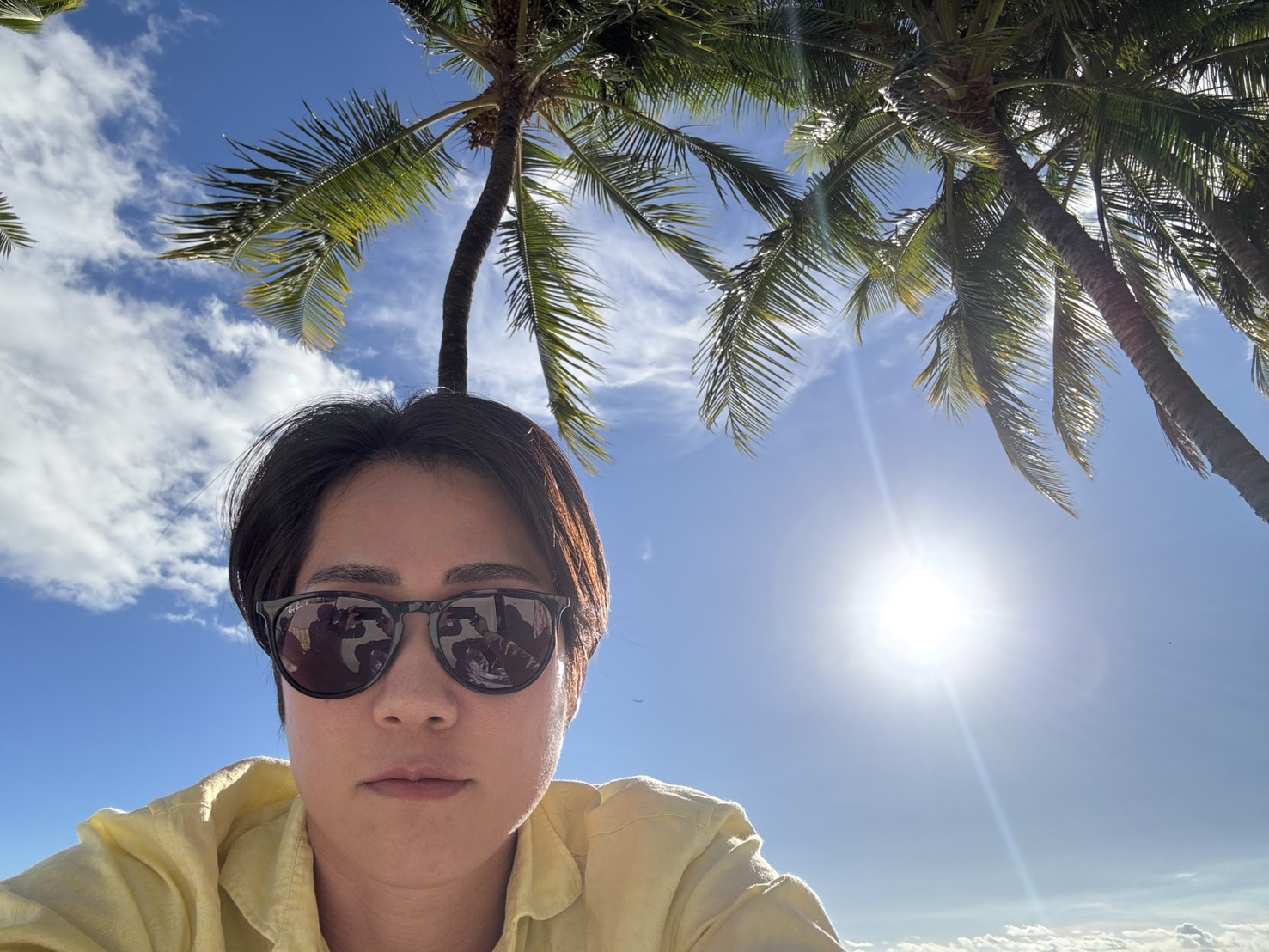 ハワイの青空を背景に写真を撮る鉢嶺